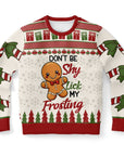 Cream and red Christmas sweater featuring gingerbread man and bold text reading “Don’t Be Shy Lick My Frosting” — playful holiday design from CollegeWares.