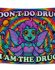Rainbow psychedelic flag featuring a purple-haired fairy with teal skin, wide orange eyes, and sparkly wings, surrounded by stars, hearts, mushrooms, and planets — with bold text that says “I Don’t Do Drugs, I Am The Drug” in bubble font. Funny trippy dorm flag for stoners, festival girls, and chaotic college vibes by CollegeWares.