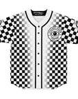 Front of a black-and-white checkerboard EDM baseball jersey with a gradient fade toward the center, featuring a circular “Cyclops Vision Center” crest on the left chest with a bold black single eye logo in the middle. Buttons run down the center with clean black piping. Sleeves include green-and-black single-eye patches on each arm. CollegeWares Rave Collection tag visible inside collar.