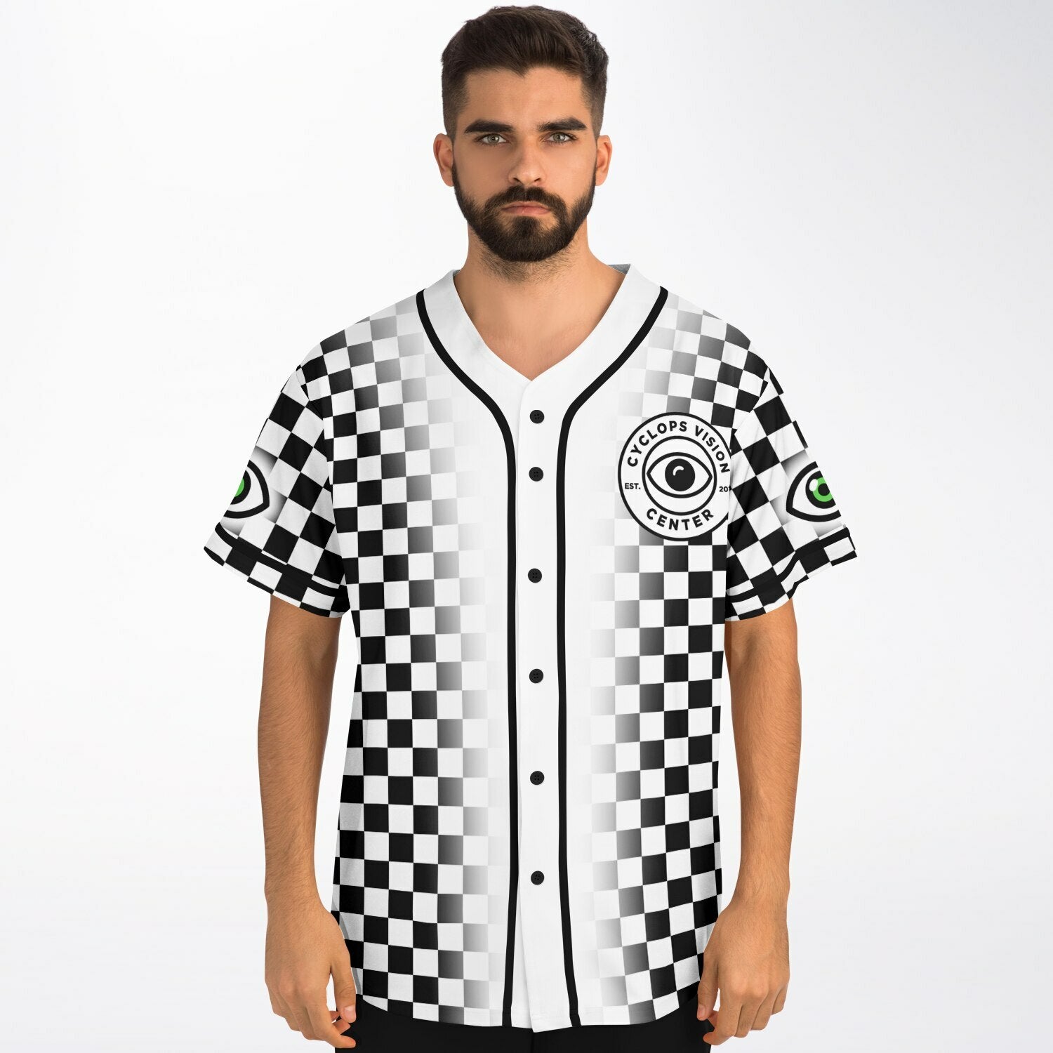 Front of a black-and-white checkerboard baseball jersey worn by a man. The chest features the “Cyclops Vision Center” circular crest with a bold black-and-green eye logo. Black piping lines the button-up center. Sleeves show green-eye patches on both sides.
