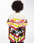 Back view of a woman wearing the IN-N-OUT–inspired Drum-N-Bass jersey, showing the red and yellow chevron layout, parody arrow logo across the upper back, and three black palm-tree silhouettes at the bottom.