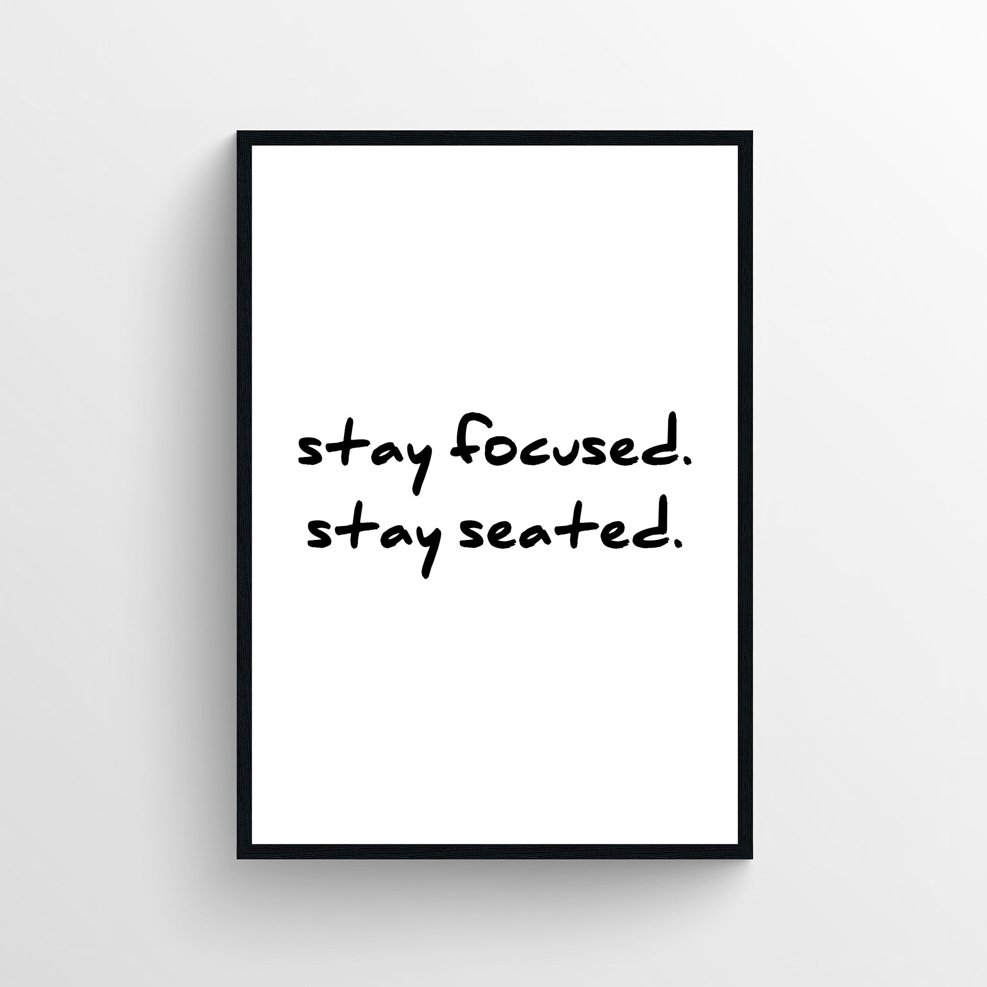 Minimalist funny bathroom poster with the text “stay focused. stay seated.” in handwritten typography. Simple bathroom wall art designed for guest bathrooms and restrooms from CollegeWares.