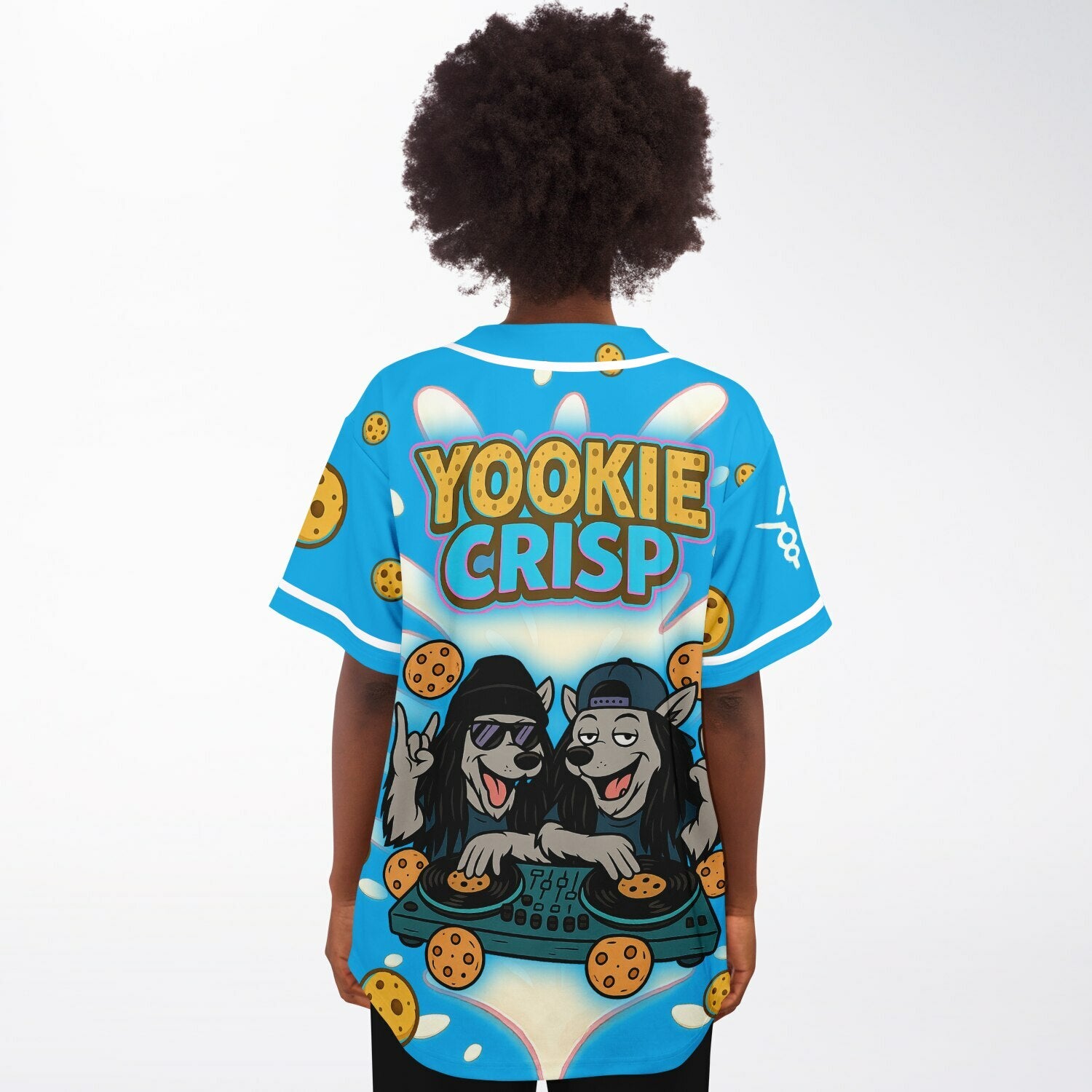 Female model wearing Yookie Crisp baseball jersey back view, featuring playful Yookie Crisp logo, DJ wolf duo, cookie graphics, and creamy milk splash.